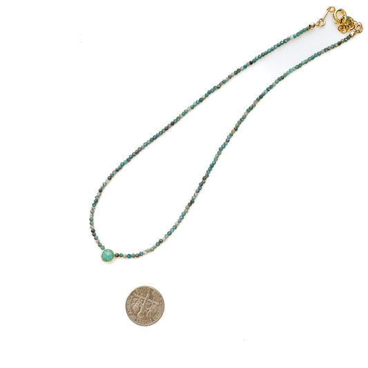 Necklace with beads and a coin pendant on a white background