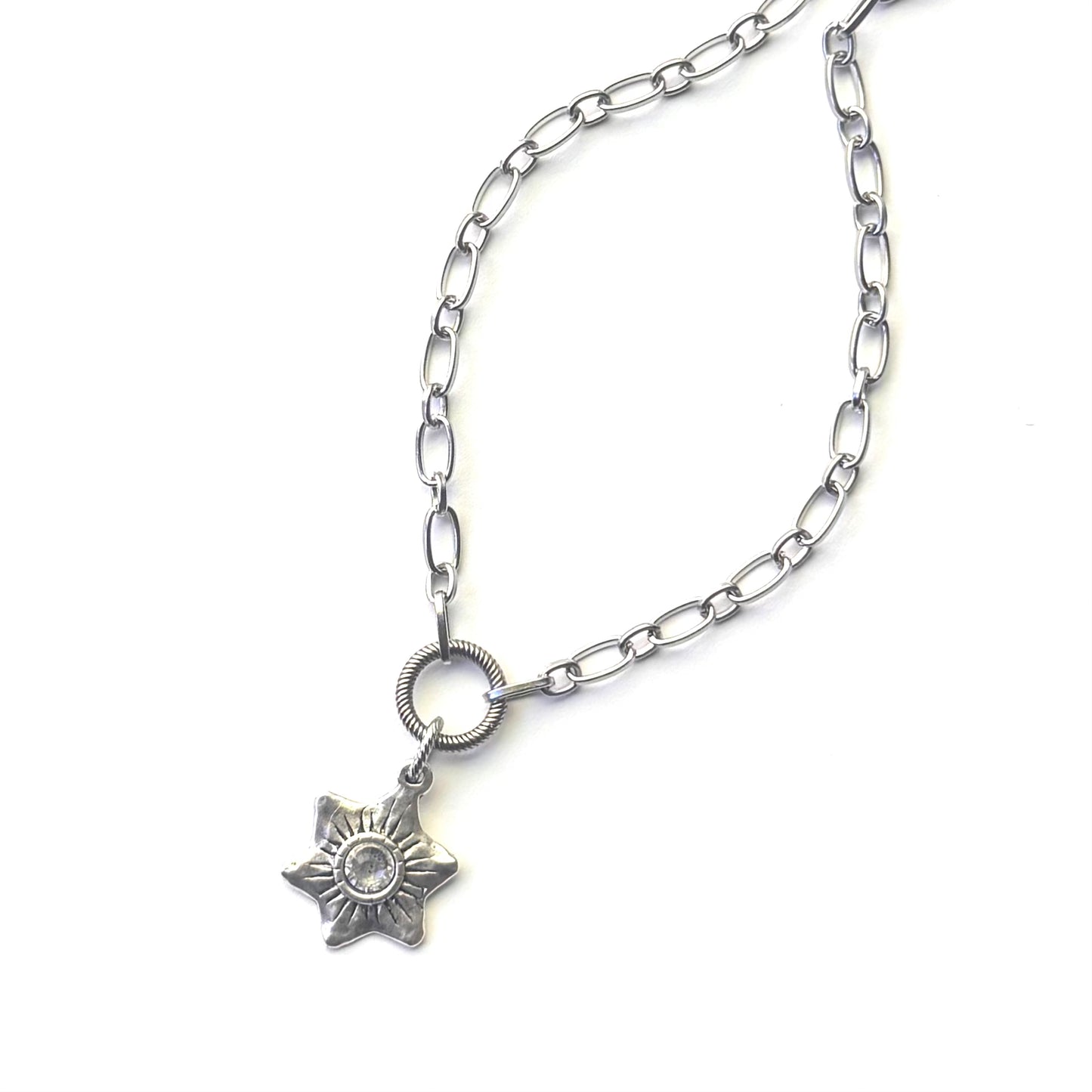 A silver-toned chain necklace featuring a six-pointed star pendant with a clear central gemstone, displayed on a clean white background.
