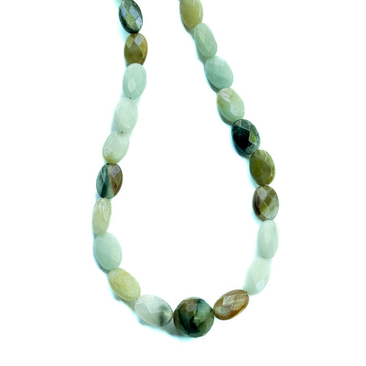 Necklace with green and white beaded strands on a white background
