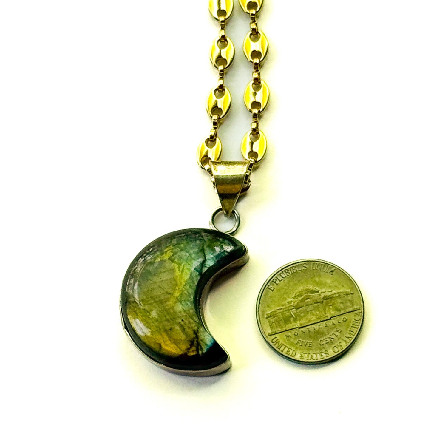 Gold chain necklace with a green stone pendant next to a U.S. quarter for size comparison on a white background.