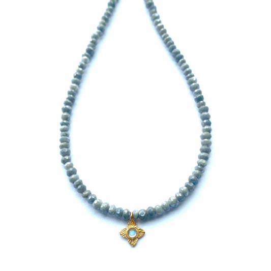 Necklace with gray beads and a gold pendant on a white background