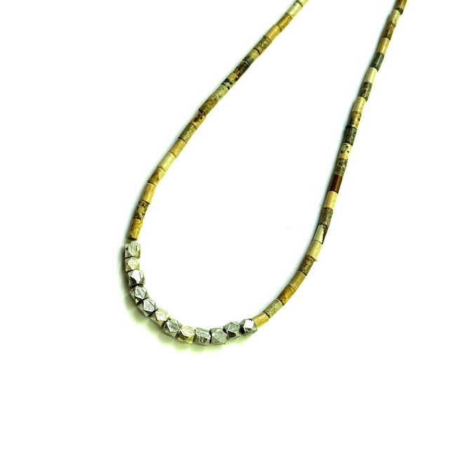 Necklace with tan and silver beads on a white background