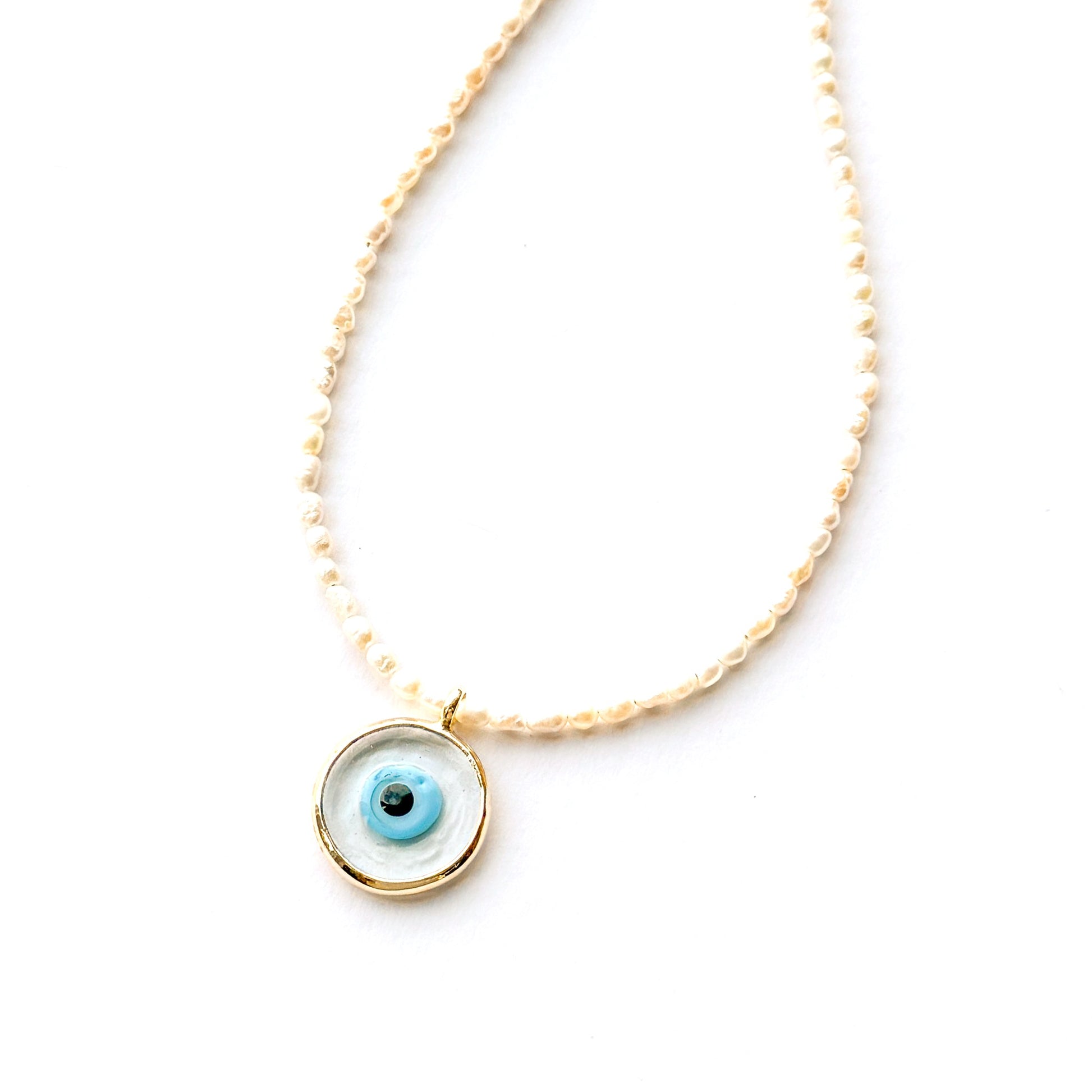 Necklace with a circular pendant featuring an eye design on a white background