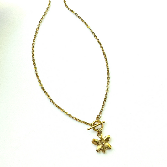 A gold chain necklace with a toggle clasp and a small butterfly charm, displayed on a clean white background.
