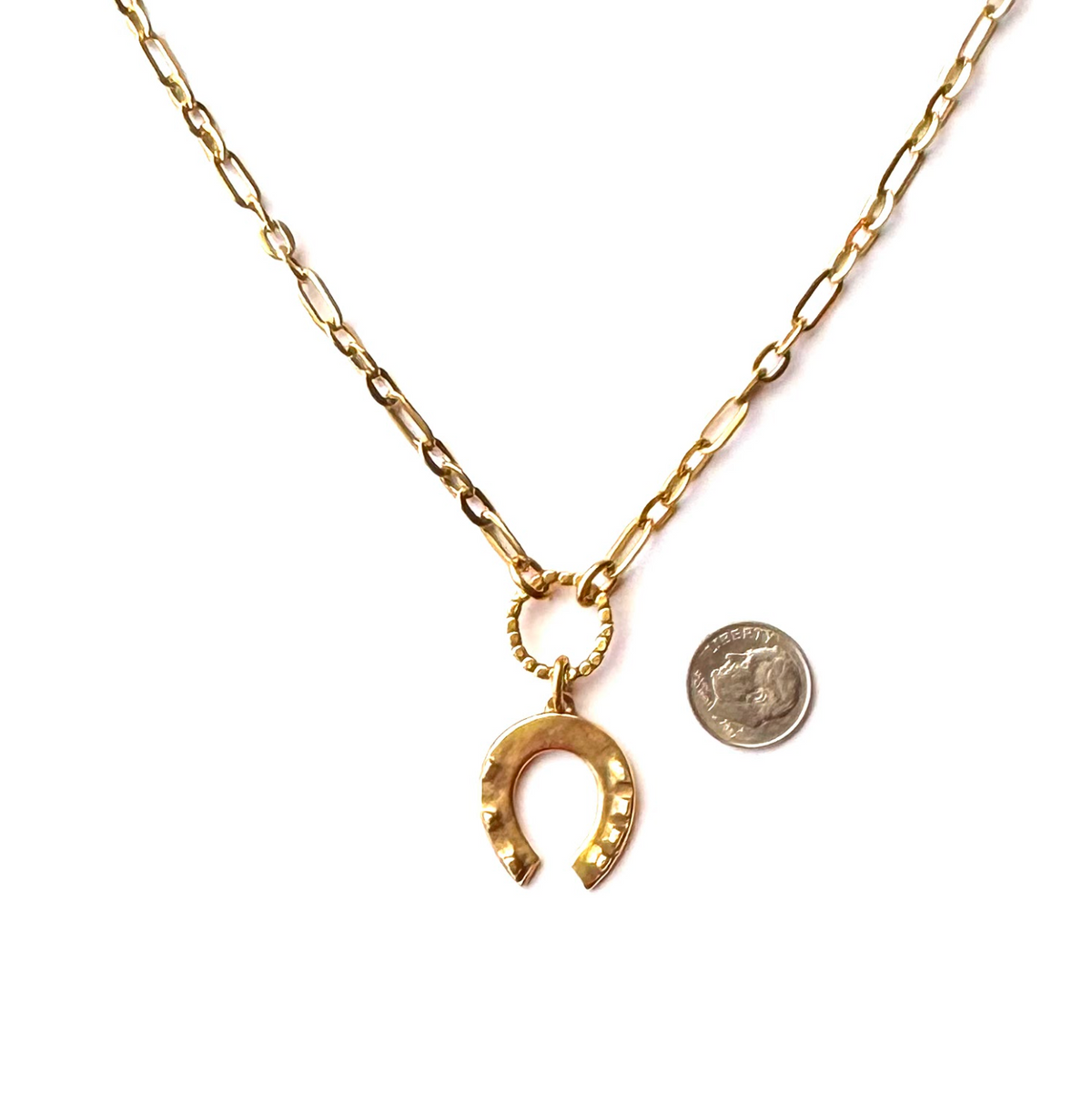 A gold-tone chain necklace with a small ring connector and a horseshoe-shaped pendant, shown on a white background with a U.S.