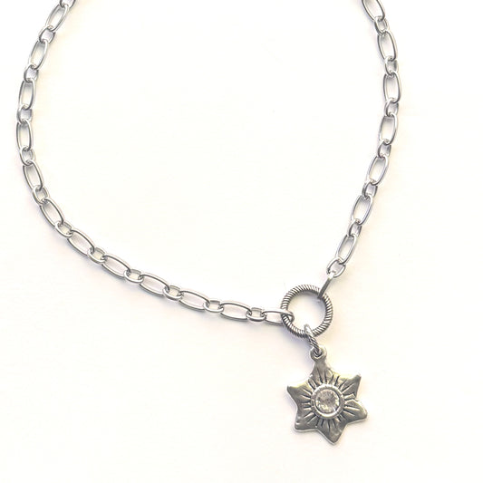A silver-toned chain necklace featuring a small six-pointed star pendant with a clear rhinestone in the center, displayed on a clean white background.