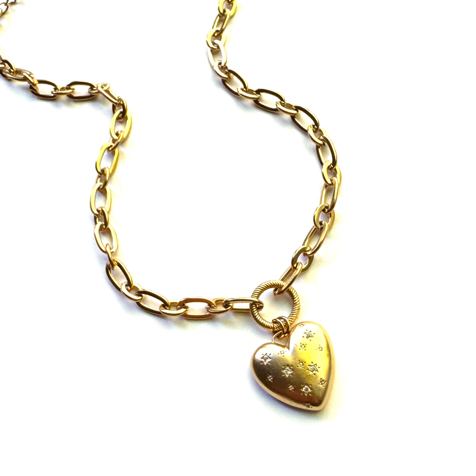 Gold toned necklace with heart pendent embellished by small crystals held together by a circle accent. 