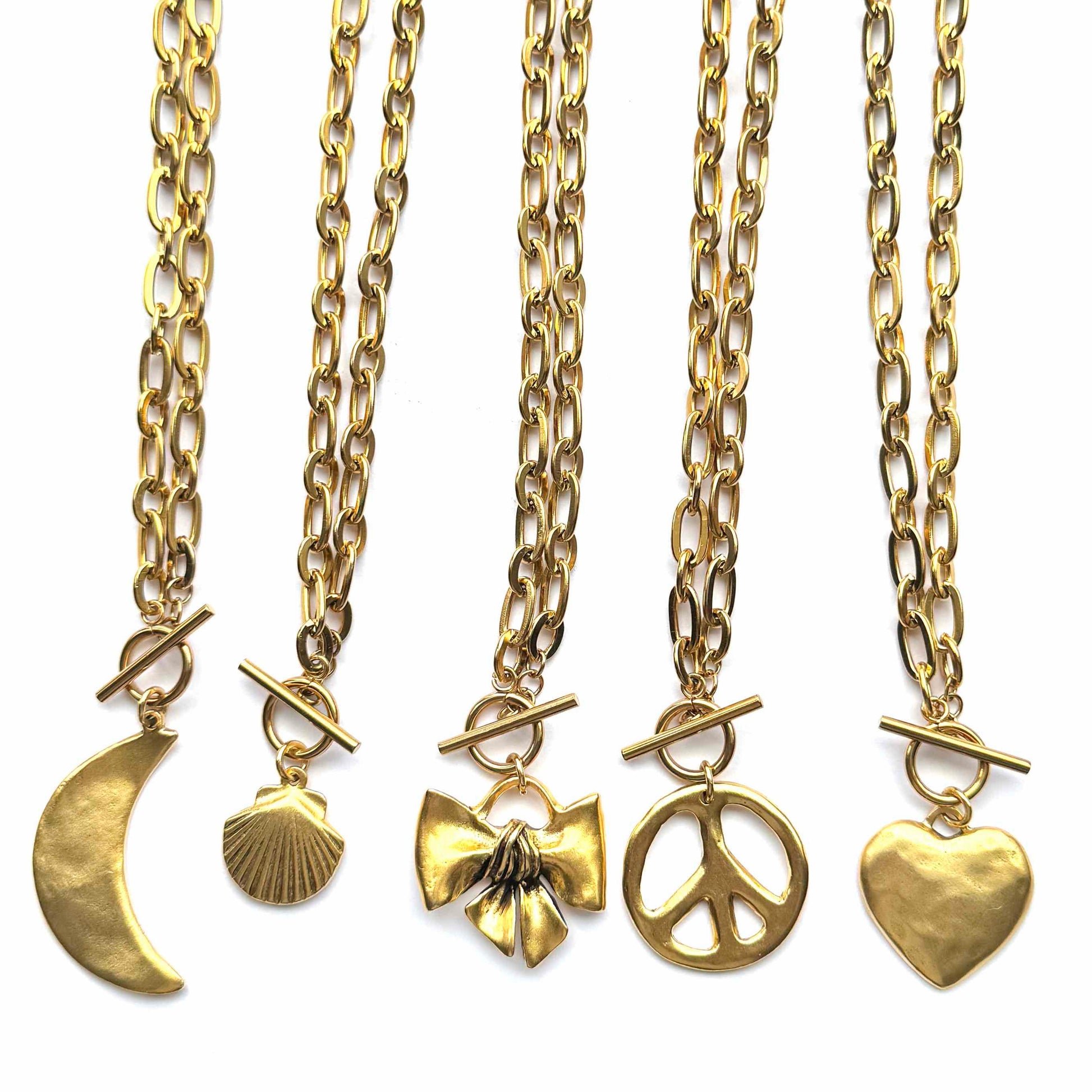 Set of five gold necklaces with various pendants on a white background