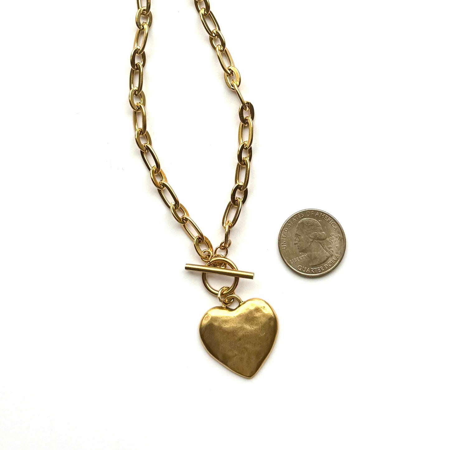 Gold heart-shaped pendant necklace with a chain on a white background