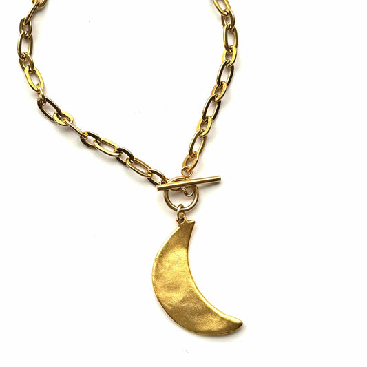 Gold necklace with a crescent moon pendant on a white background