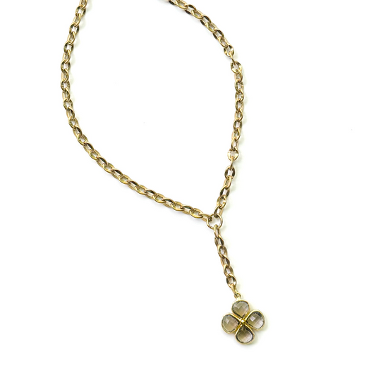 A gold-toned chain necklace with a Y-shaped drop and a four-petal flower charm made of faceted gemstones, shown on a plain white background.