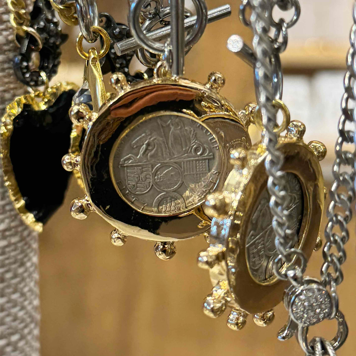 Close-up of a necklace with various pendants, including a coin charm.