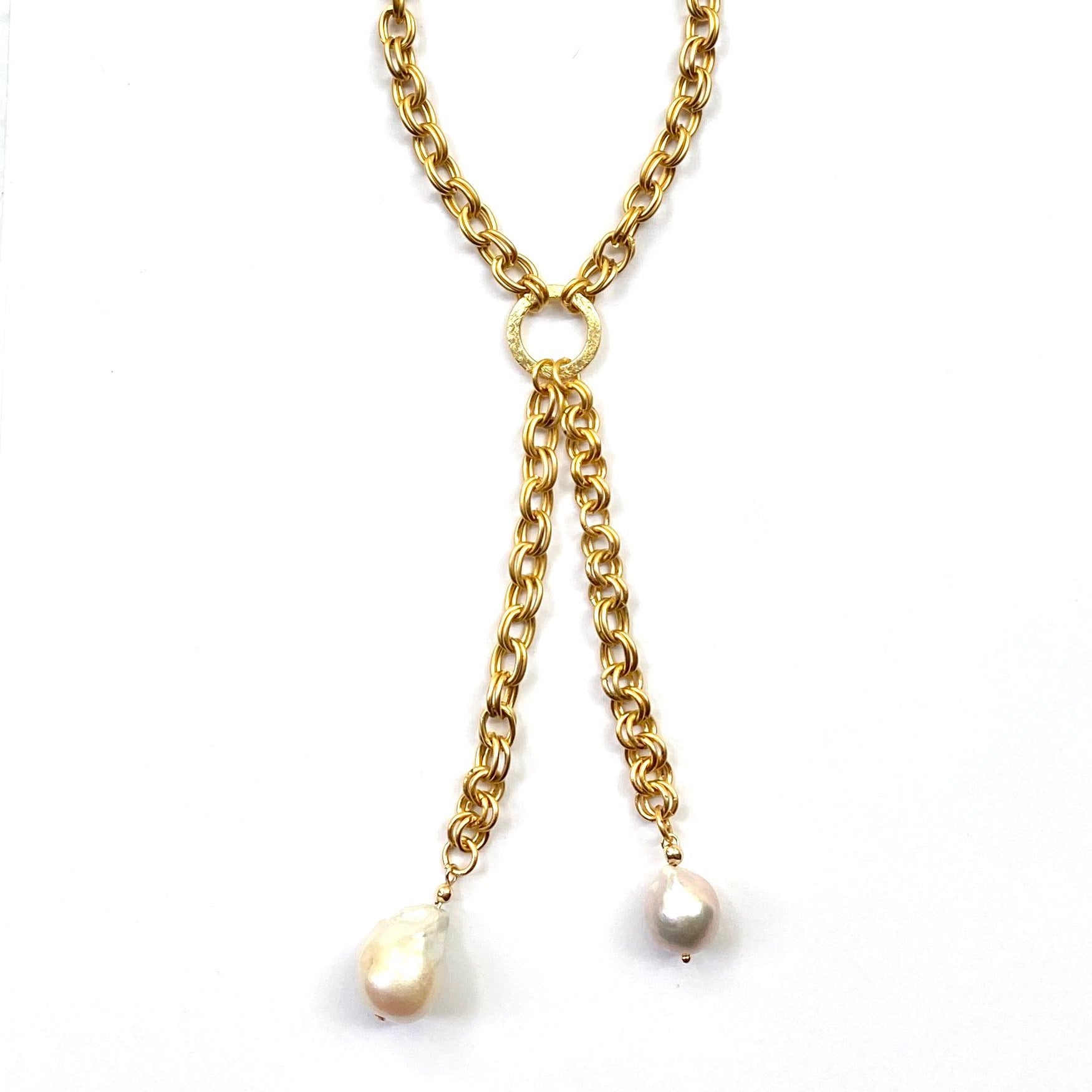 Gold chain necklace with pearl pendants on a white background