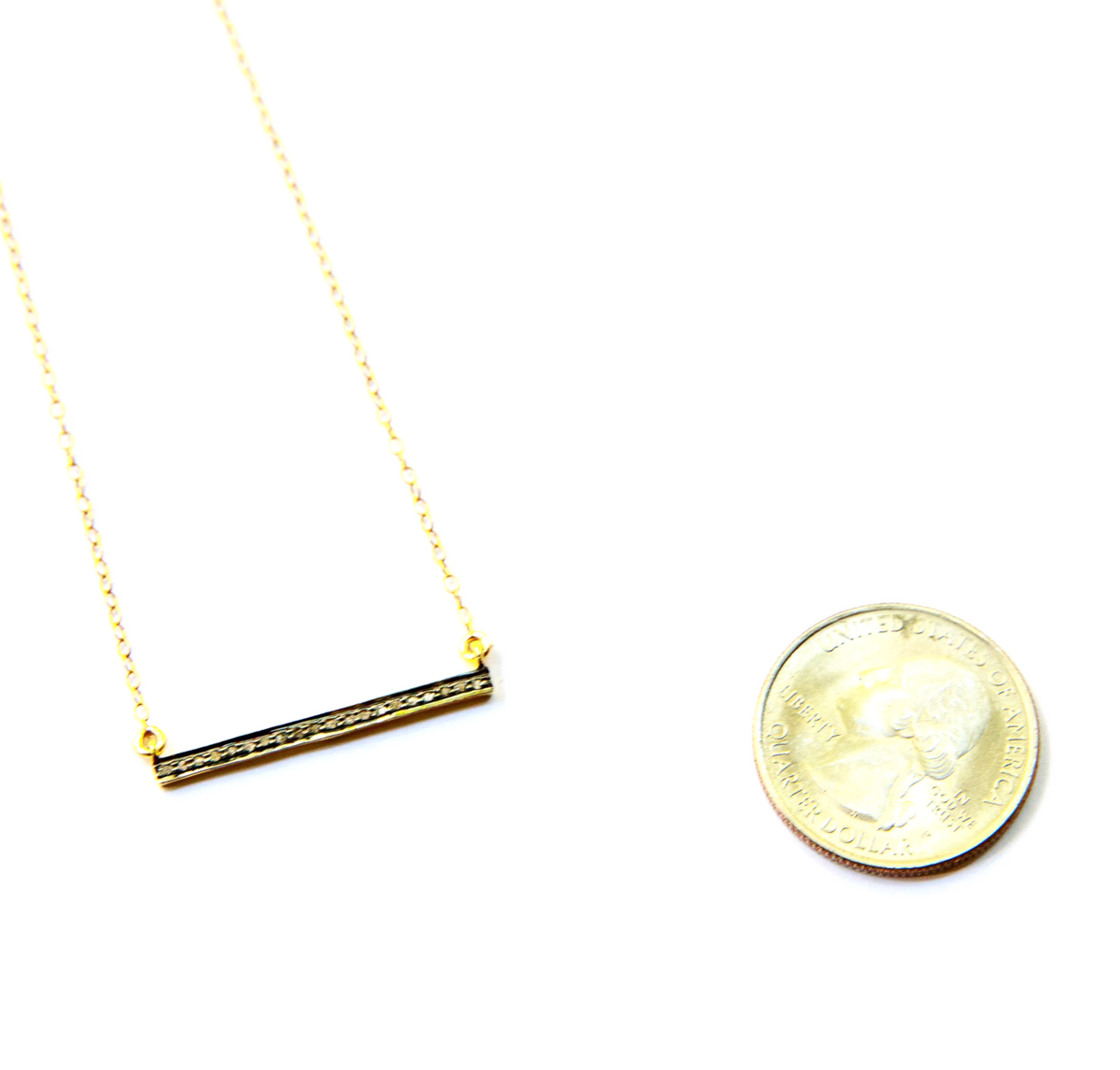 Gold necklace with a bar pendant on a white background