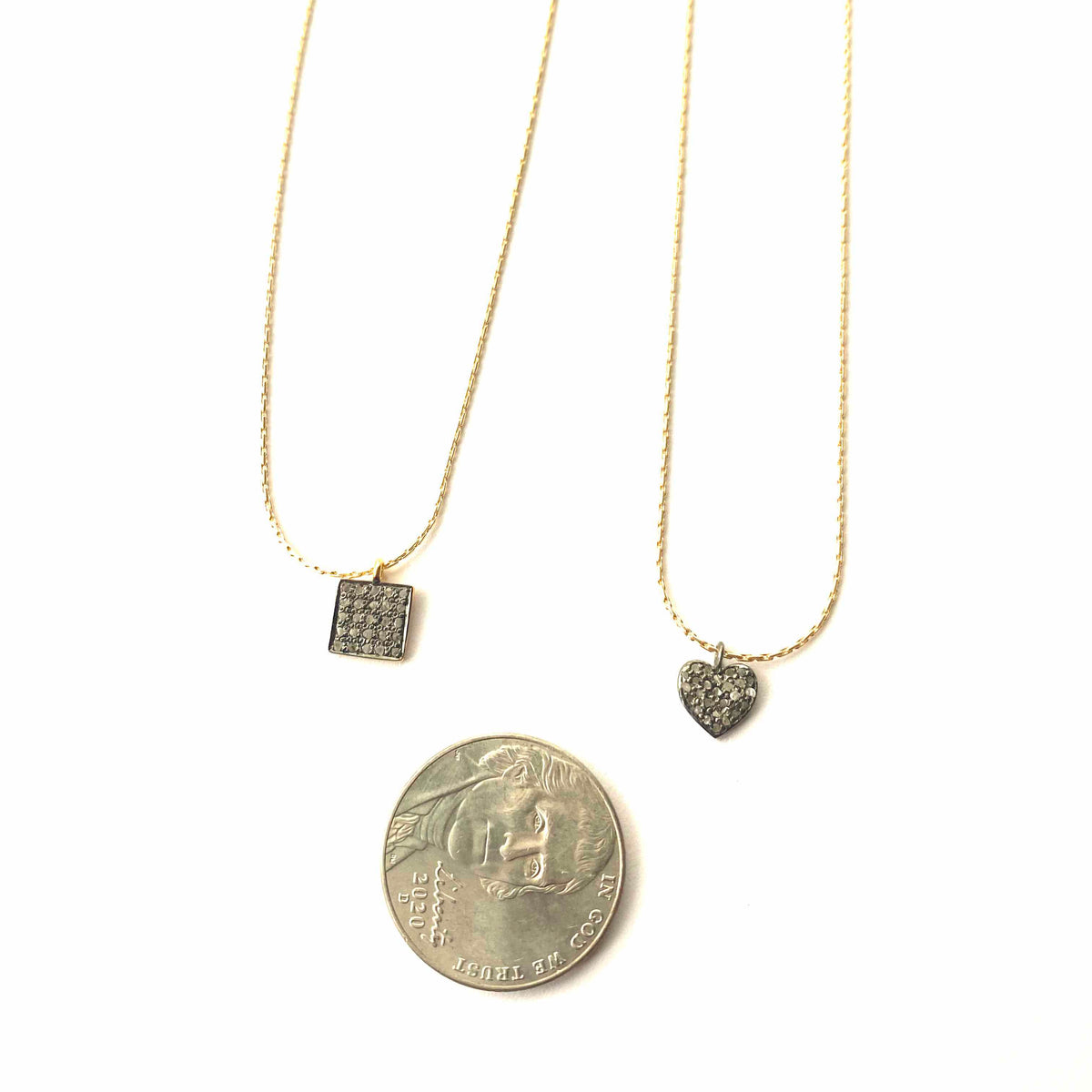 Three necklaces with different pendants on a white background