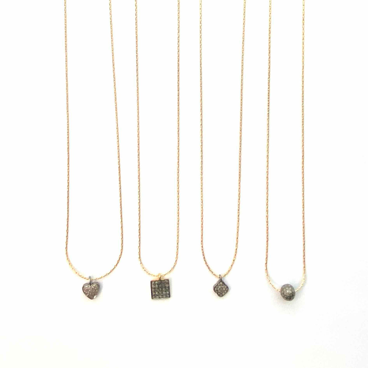 Four gold necklaces with various pendants on a white background