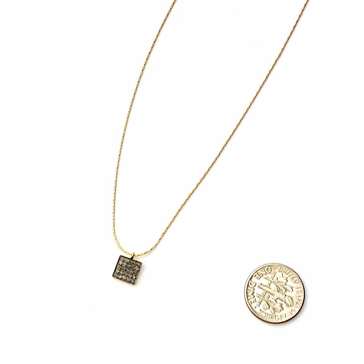 Gold necklace with a square pendant and round medallion on a white background