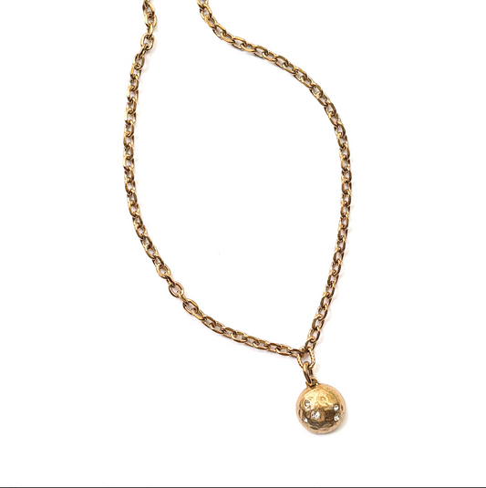 A gold chain necklace with a small, textured spherical pendant, displayed on a clean white background.