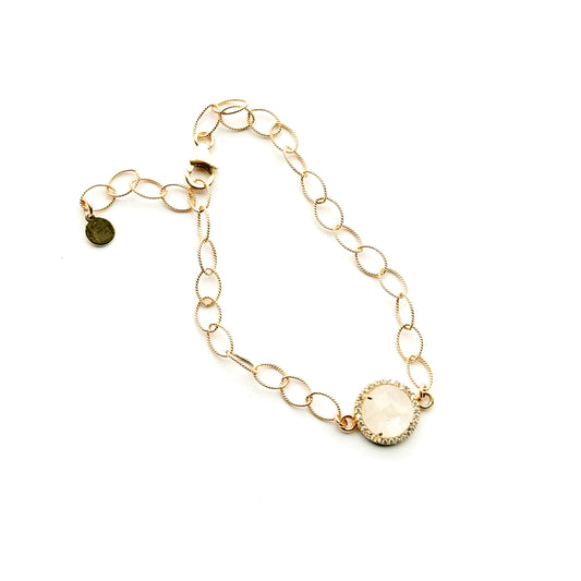 Gold chain bracelet with moonstone circular pendants on a white background