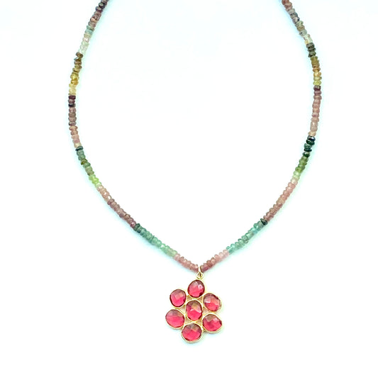 Necklace with multicolored beads and a pink floral pendant on a white background